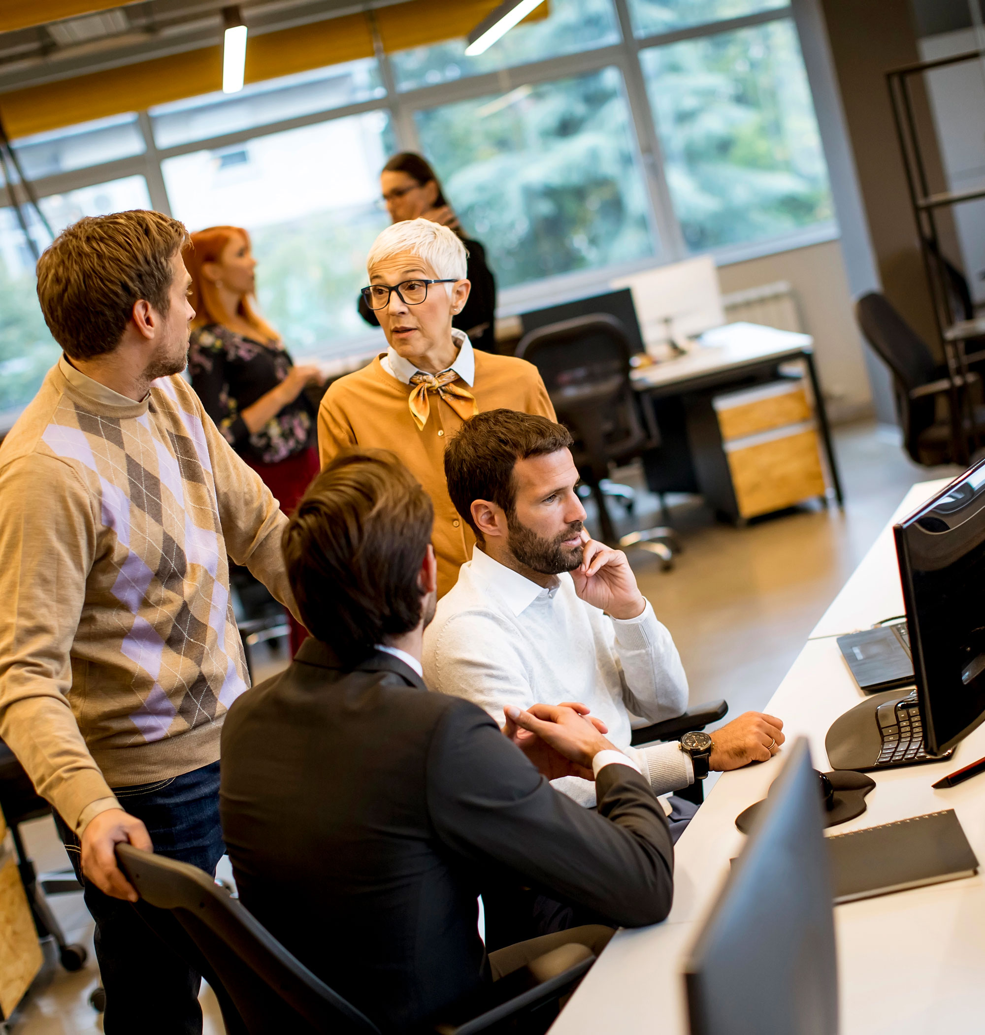 Group of diverse employees discussing work together